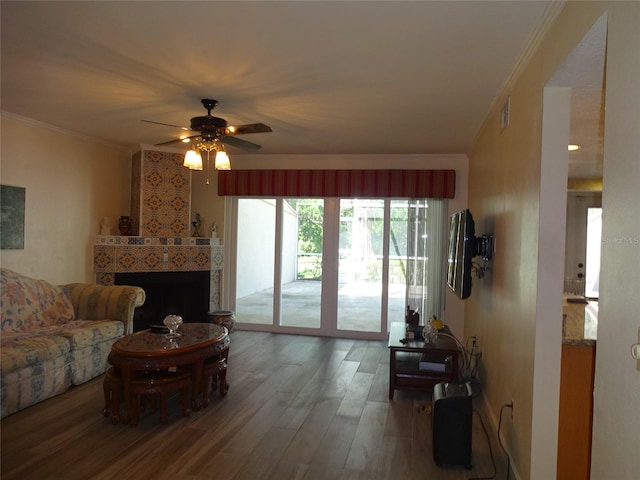 living room with ornamental molding, a fireplace, wood-type flooring, and ceiling fan