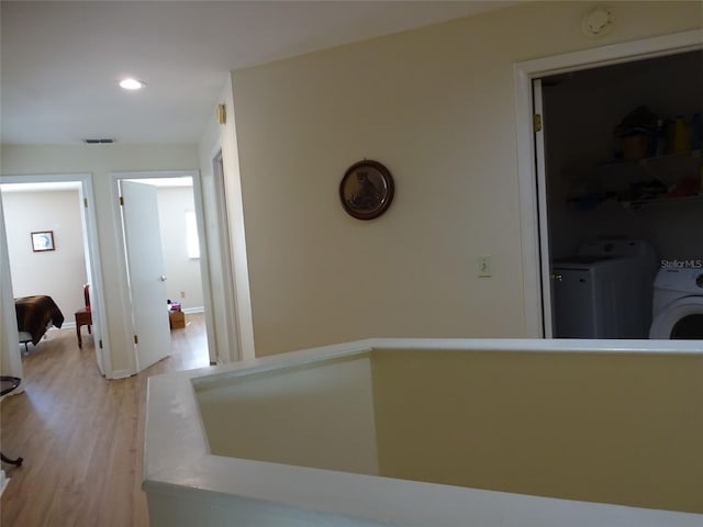 hall featuring independent washer and dryer and light hardwood / wood-style floors