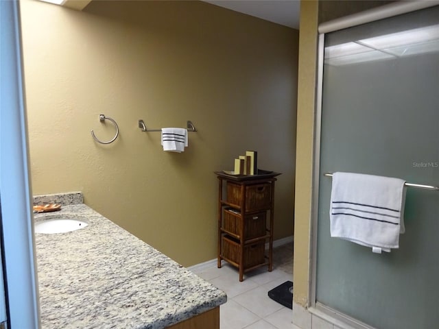 bathroom featuring a shower with door, vanity, and tile patterned floors