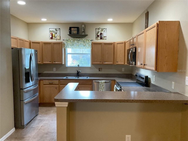 kitchen with kitchen peninsula, light tile patterned floors, appliances with stainless steel finishes, light brown cabinetry, and sink