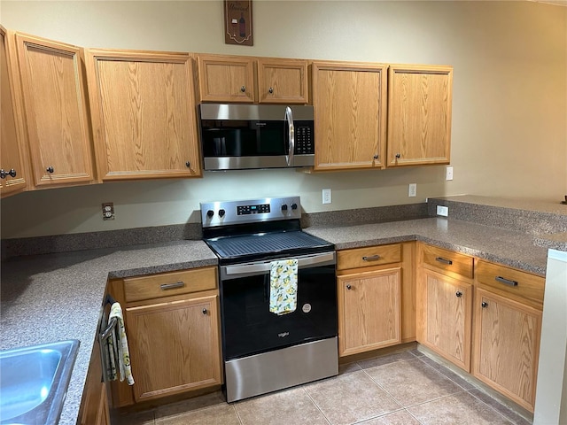 kitchen featuring appliances with stainless steel finishes, sink, and light tile patterned floors