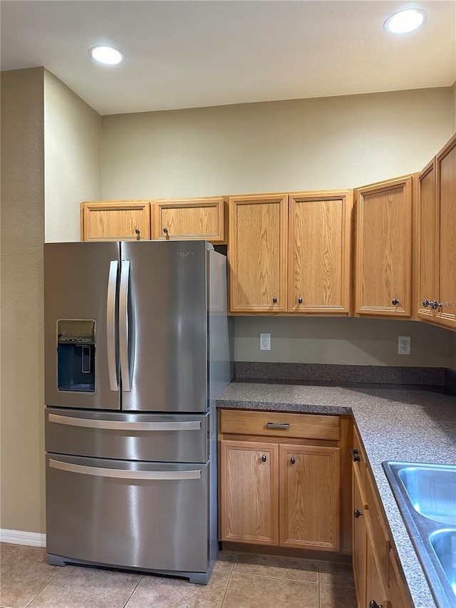 kitchen featuring stainless steel refrigerator with ice dispenser, light tile patterned flooring, and sink