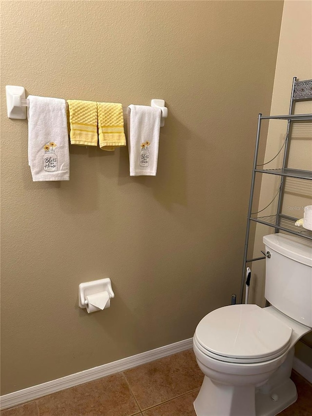 bathroom with toilet and tile patterned floors