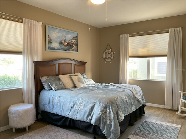 bedroom featuring multiple windows and hardwood / wood-style flooring