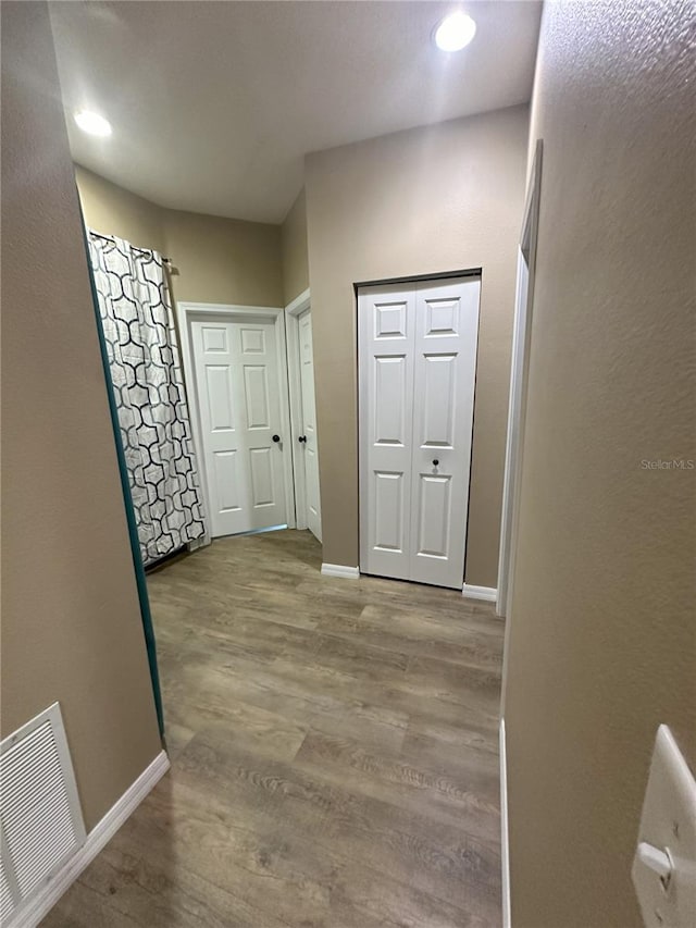 corridor with hardwood / wood-style flooring