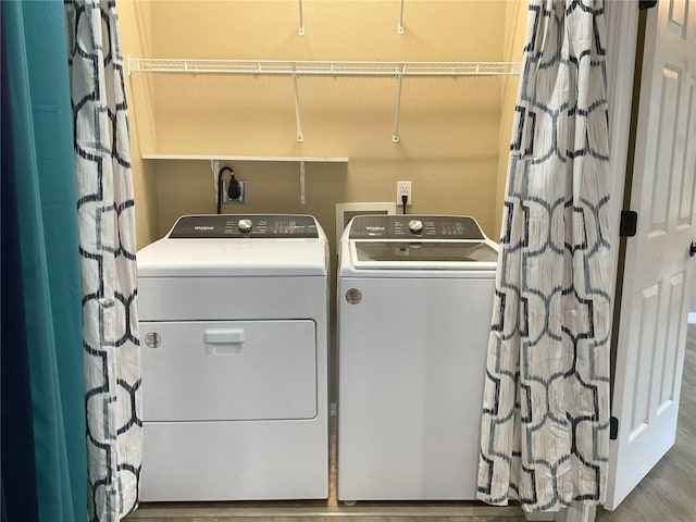 laundry area featuring hardwood / wood-style floors and washing machine and dryer