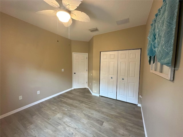 unfurnished bedroom with a closet, hardwood / wood-style floors, and ceiling fan