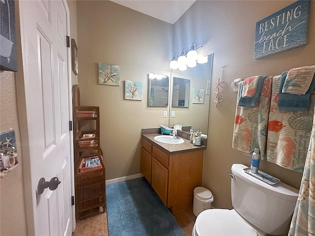 bathroom with toilet, vanity, and tile patterned flooring