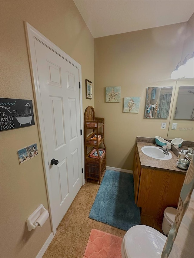 bathroom with vanity, toilet, and tile patterned floors