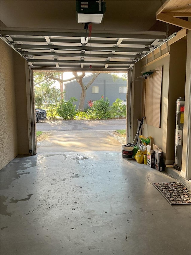 garage with a garage door opener and electric water heater