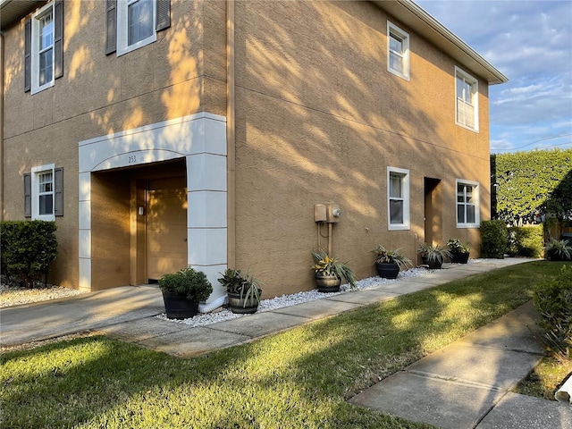 view of property exterior featuring a lawn and elevator