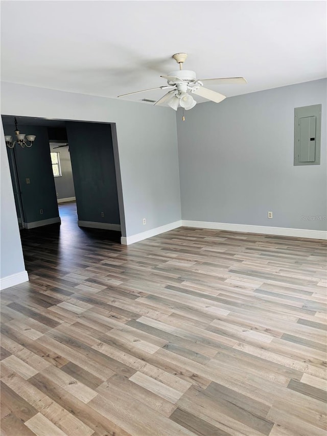 empty room featuring light hardwood / wood-style floors, electric panel, and ceiling fan