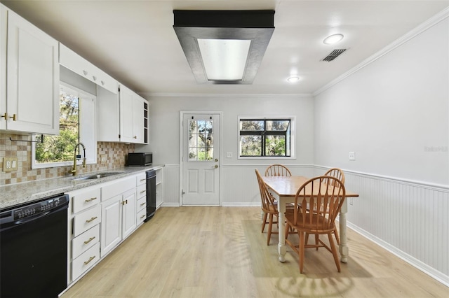 kitchen with plenty of natural light, black dishwasher, and backsplash