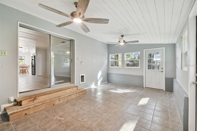 unfurnished sunroom with vaulted ceiling, wood ceiling, and ceiling fan