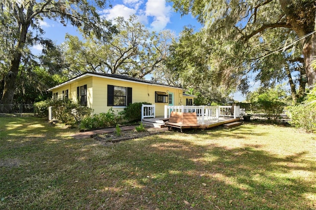 rear view of house with a yard and a deck