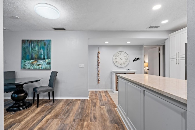 kitchen with white cabinetry, dark hardwood / wood-style floors, and a textured ceiling