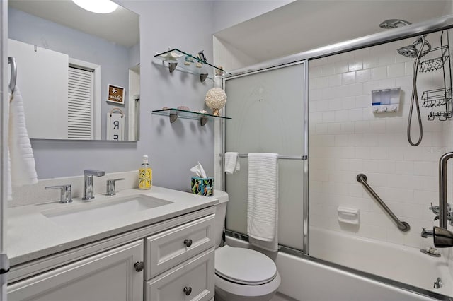 full bathroom featuring vanity, combined bath / shower with glass door, and toilet