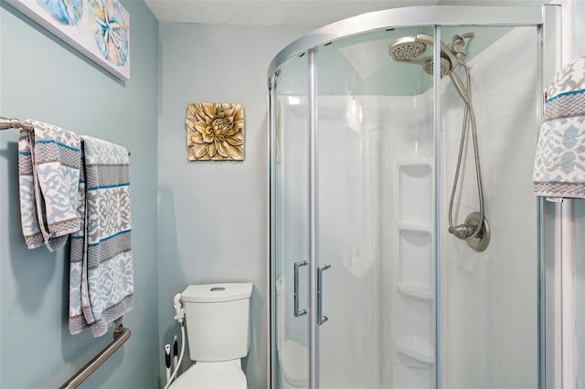 bathroom with toilet and an enclosed shower