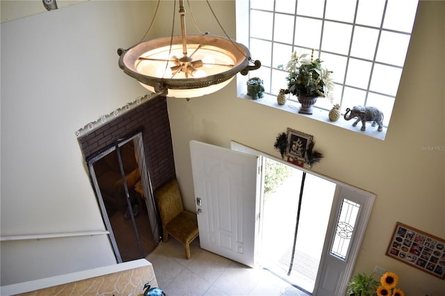 foyer entrance featuring a high ceiling and a fireplace