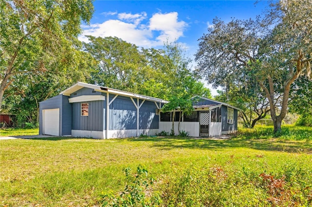 back of house with a yard, an outdoor structure, and a garage