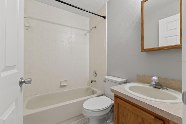 full bathroom featuring tiled shower / bath, vanity, toilet, and a textured ceiling