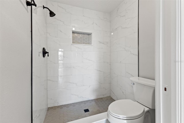 bathroom with tiled shower and toilet