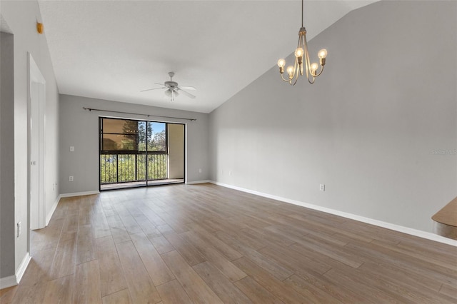 unfurnished room with ceiling fan with notable chandelier, vaulted ceiling, and light hardwood / wood-style floors