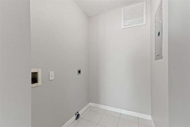 clothes washing area featuring light tile patterned flooring, hookup for an electric dryer, electric panel, and a textured ceiling