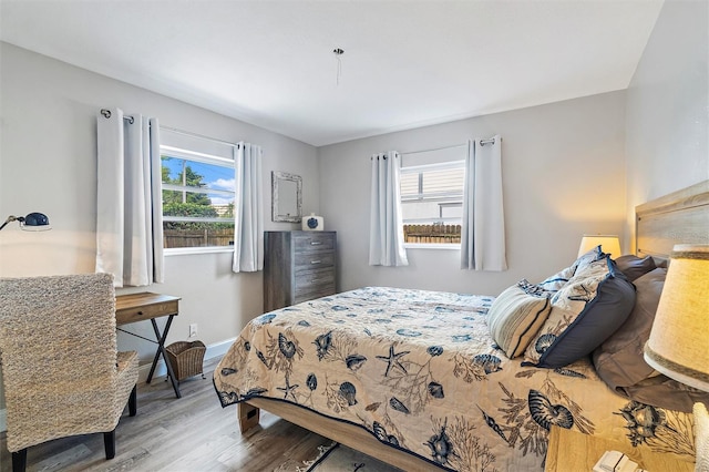 bedroom with multiple windows and wood-type flooring