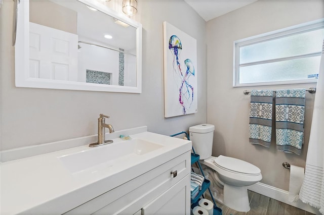 bathroom featuring vanity, toilet, and hardwood / wood-style flooring