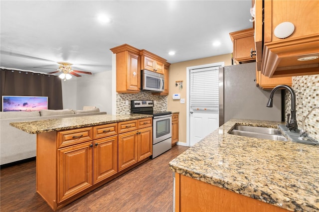 kitchen featuring tasteful backsplash, ceiling fan, dark wood-type flooring, sink, and stainless steel appliances