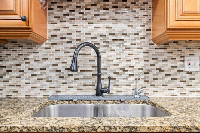 5621 Moog Rd, New Port Richey, FL 34652 - kitchen view of a sink, backsplash, and light stone countertops