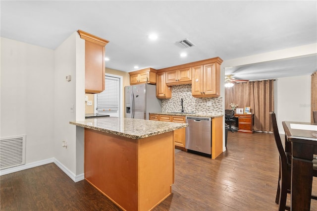 kitchen featuring kitchen peninsula, stainless steel appliances, light stone countertops, dark hardwood / wood-style flooring, and ceiling fan