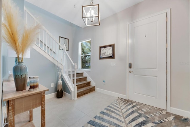 entryway featuring tile patterned flooring, stairs, baseboards, and a chandelier