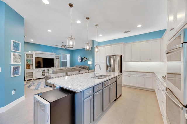 kitchen featuring white cabinetry, decorative light fixtures, and stainless steel appliances