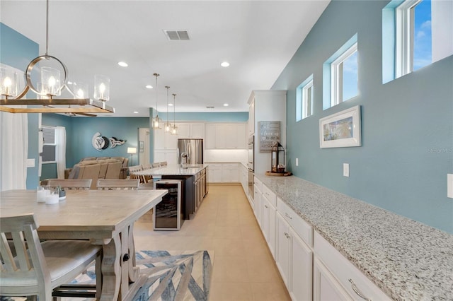 kitchen with white cabinetry, a breakfast bar, decorative light fixtures, and a kitchen island