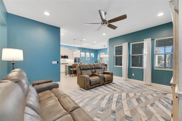 living room featuring ceiling fan with notable chandelier