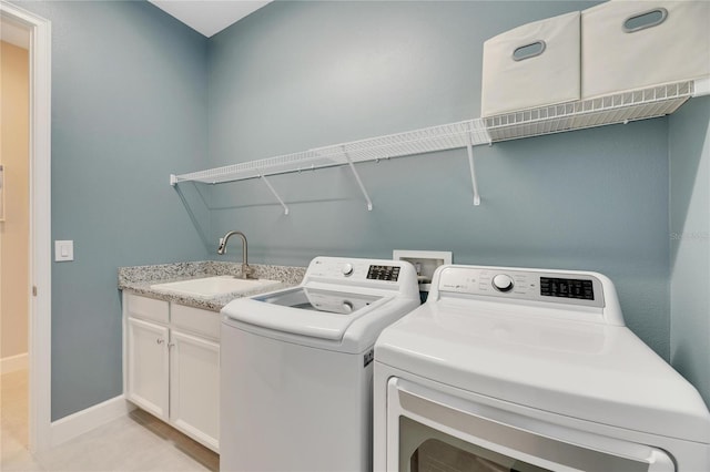 laundry area featuring sink, independent washer and dryer, cabinets, and light tile patterned floors