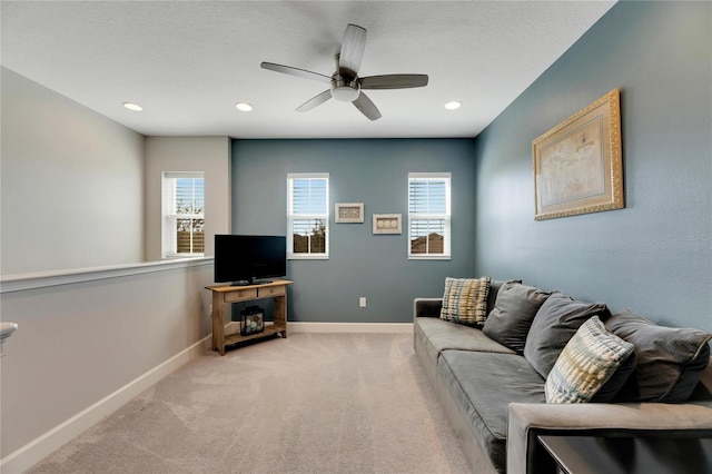 living room with light carpet, ceiling fan, and a wealth of natural light