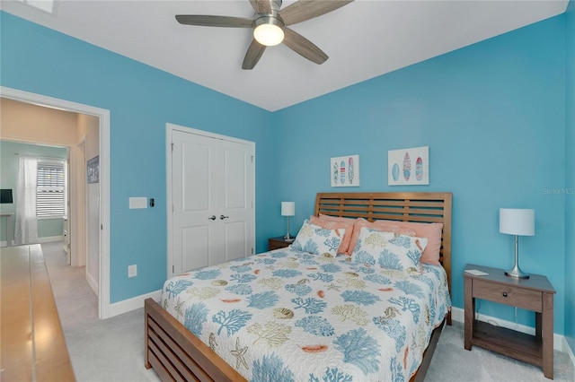 bedroom with a closet, light colored carpet, and ceiling fan