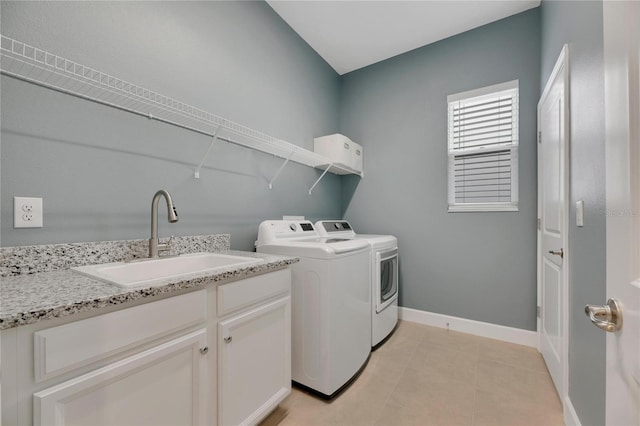 washroom with light tile patterned flooring, sink, and washing machine and clothes dryer