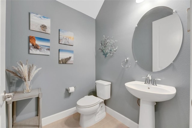 bathroom with tile patterned floors, lofted ceiling, and toilet