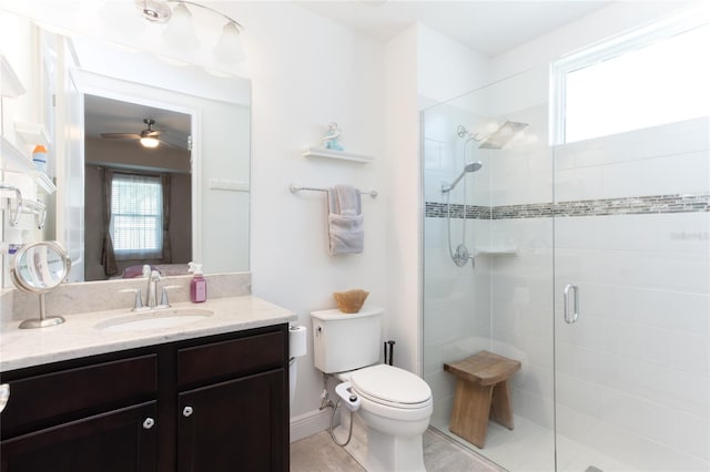 bathroom featuring vanity, a shower with shower door, toilet, and ceiling fan