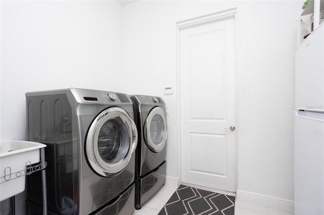 washroom with light tile patterned floors and washing machine and clothes dryer