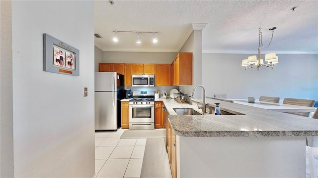 2717 Via Cipriani Unit 622B, Clearwater, FL 33764 - kitchen with stainless steel appliances, a sink, crown molding, a chandelier, and a peninsula
