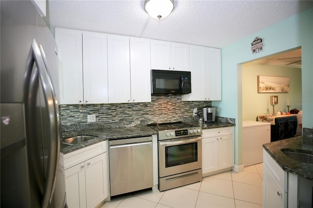 kitchen with tasteful backsplash, white cabinetry, a textured ceiling, dark stone countertops, and stainless steel appliances