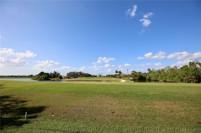 surrounding community featuring a water view and a lawn