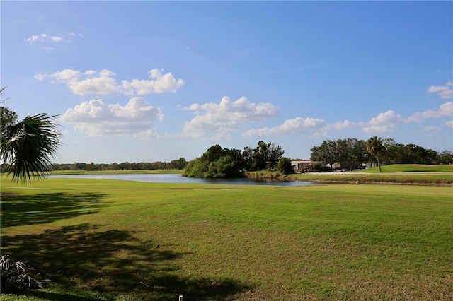 view of property's community featuring a lawn and a water view