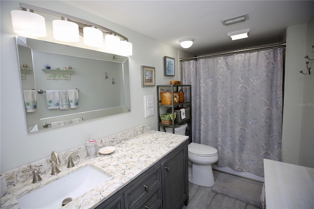 bathroom featuring vanity, toilet, hardwood / wood-style flooring, and walk in shower