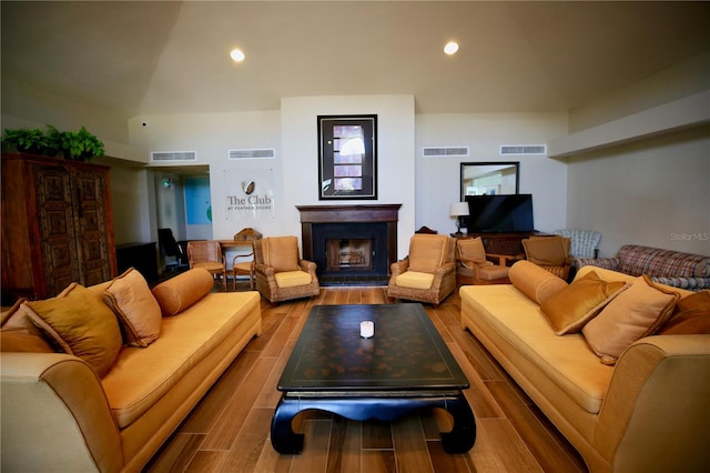 living room with hardwood / wood-style floors and vaulted ceiling